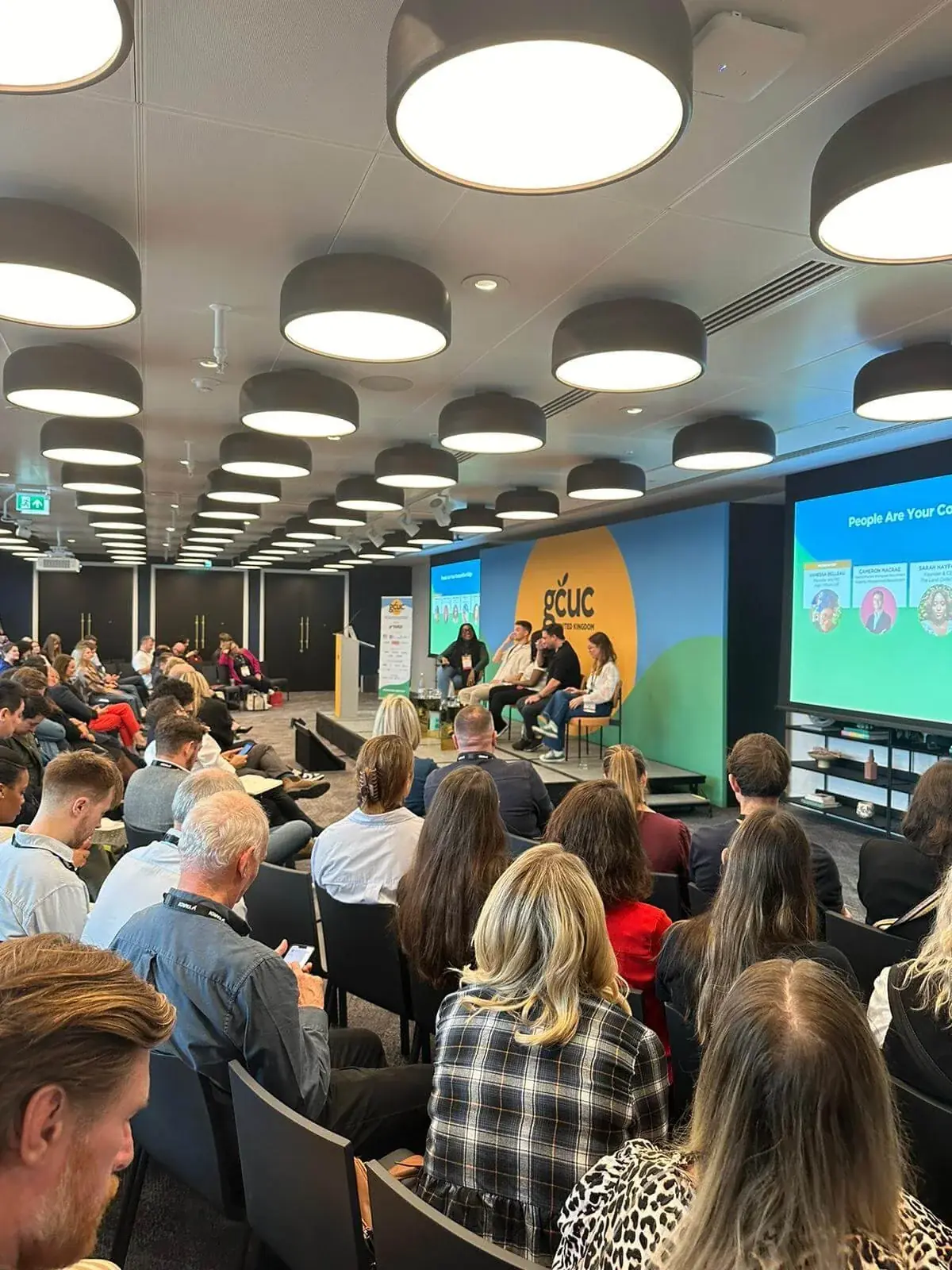 A packed conference room watching a panel