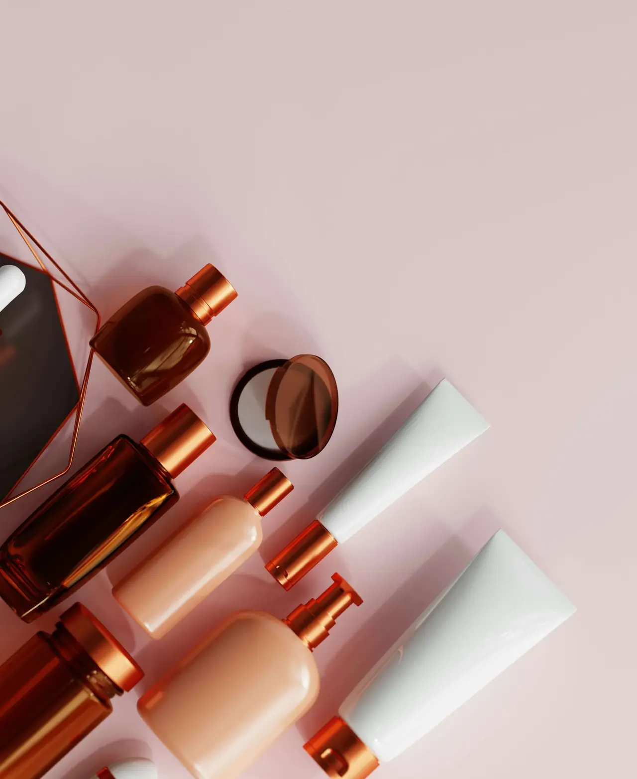 Make-up bottles and a compact mirror laid out on a pink surface