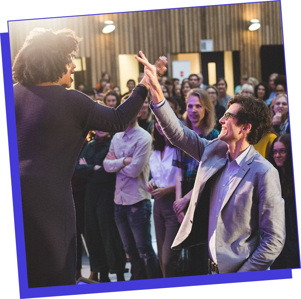 Vanessa high-fiving an audience member on stage